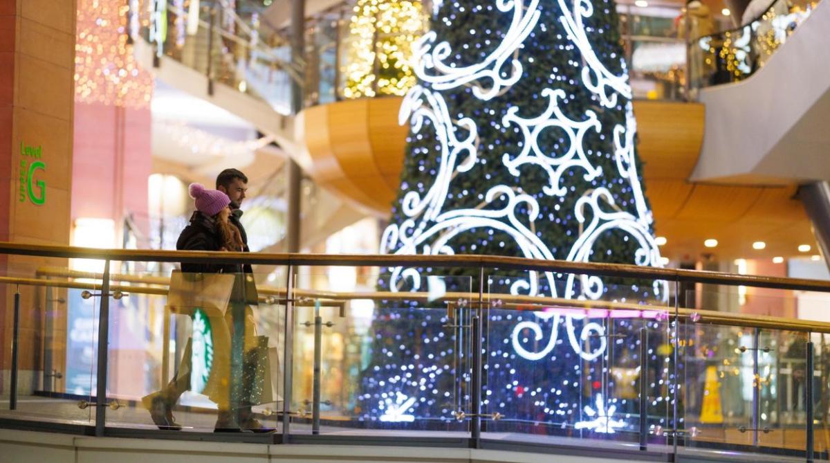 Couple walking past the Christmas Tree in Victoria Square