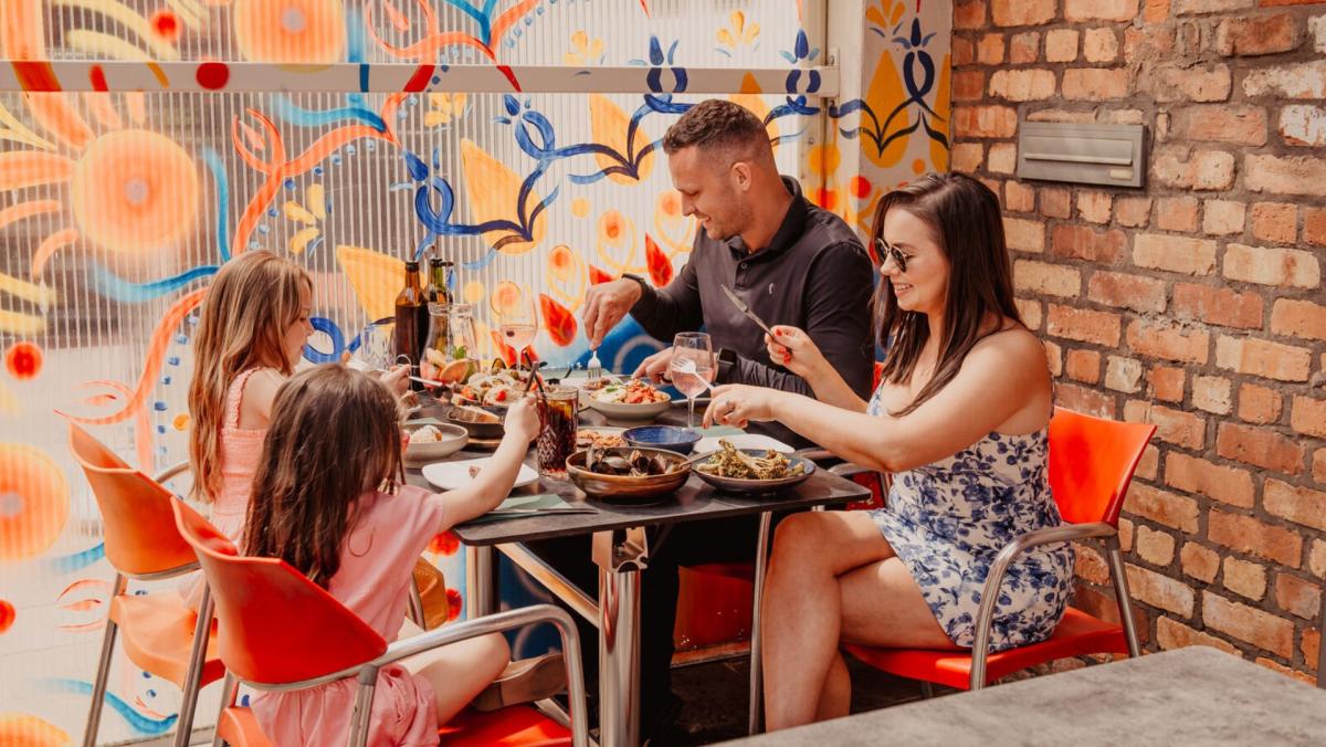 Family enjoying dinner outside at 2Taps Winebar & Restaurant.