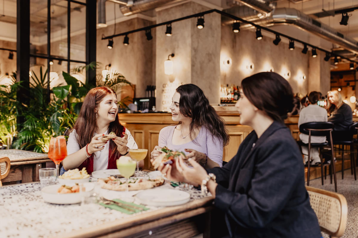 Group of girls enjoying pizza and drinks at Amelia Hall