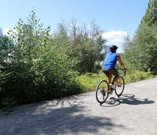 Cyclist rides the Bellevue Eastrail at The Line Bike Experience Kiosk