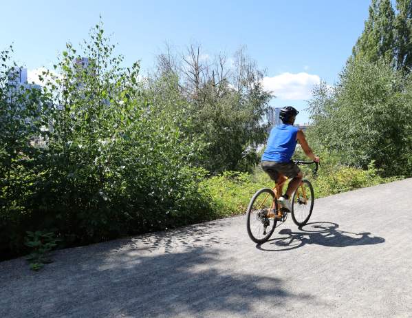 Cyclist rides the Bellevue Eastrail at The Line Bike Experience Kiosk