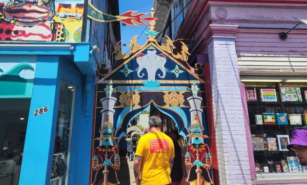 guy walking through colorful alley