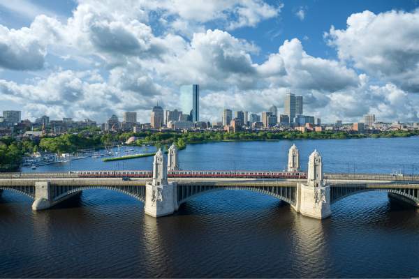 MBTA red line Train traveling over the Longfellow Bridge with the Boston skyline in the background.