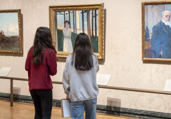 two girls viewing art of wall
