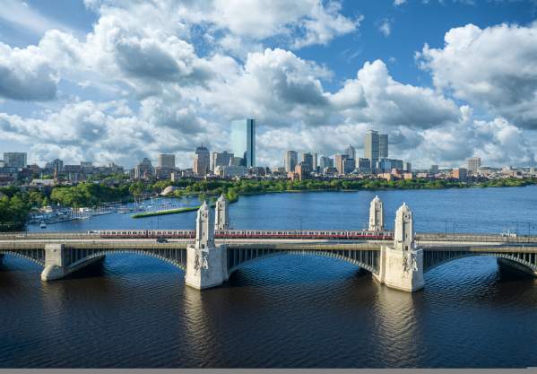 MBTA red line Train traveling over the Longfellow Bridge with the Boston skyline in the background.
