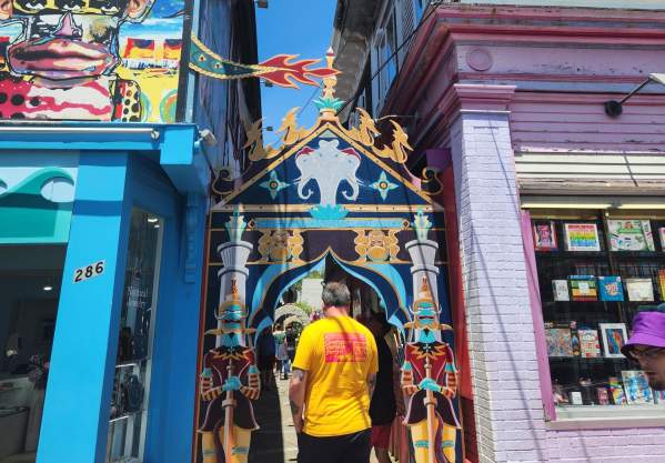 guy walking through colorful alley