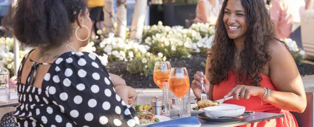 Two Black women having dinner at Alcove restaurant al fresco