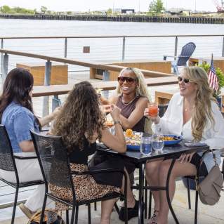 Four young women dining al fresco at 75 on Liberty, Boston