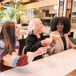 Three friends grabbing drinks during Dine Out Boston