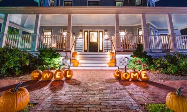 The Inn at Hastings decorated with pumpkins lit up along the front walkway.