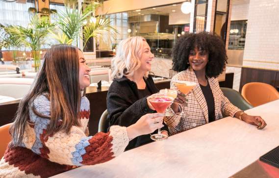 Three friends grabbing drinks during Dine Out Boston