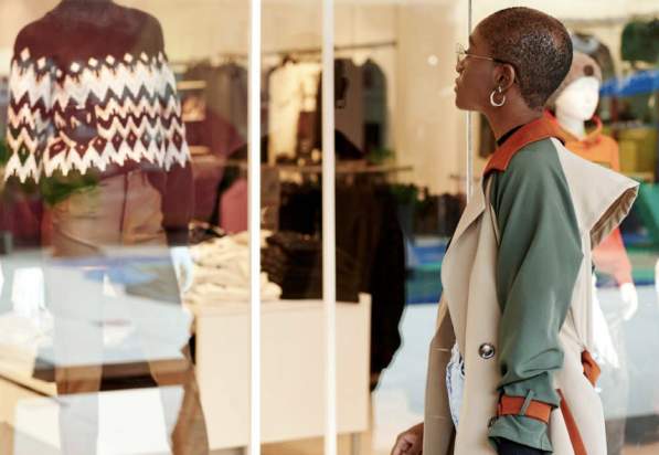 African American woman window shopping at a fashionable clothing store