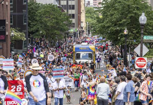 people walking down the street in celebration of the Pride Parde. featuring the mobile VIC.