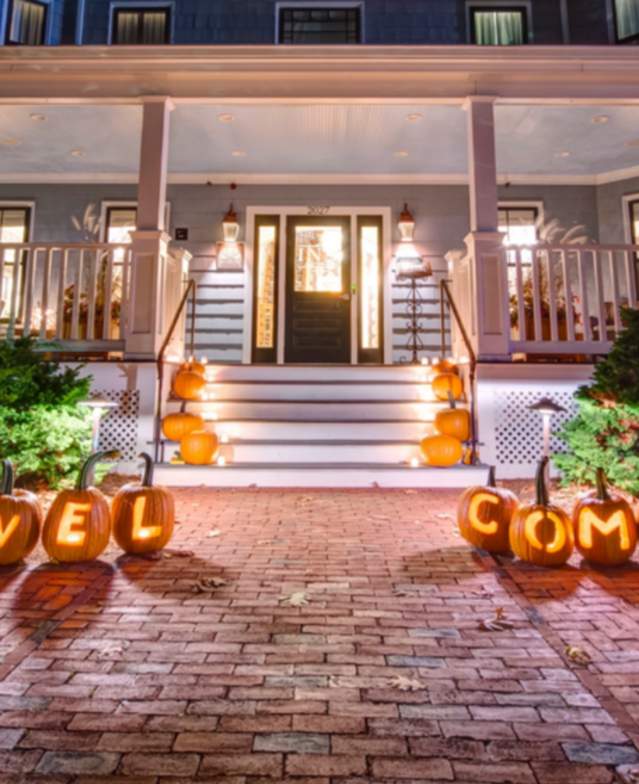 The Inn at Hastings decorated with pumpkins lit up along the front walkway.