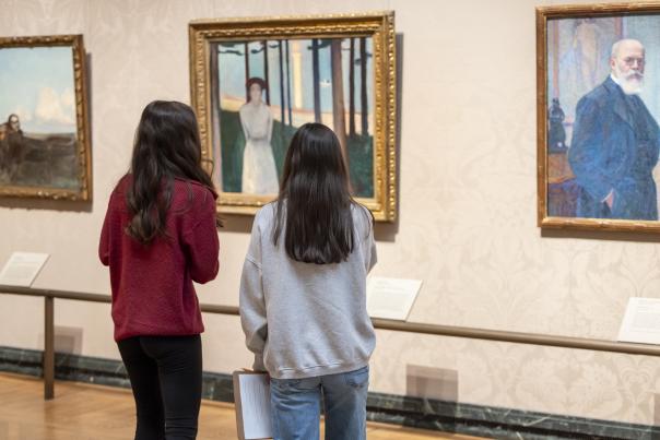 two girls viewing art of wall
