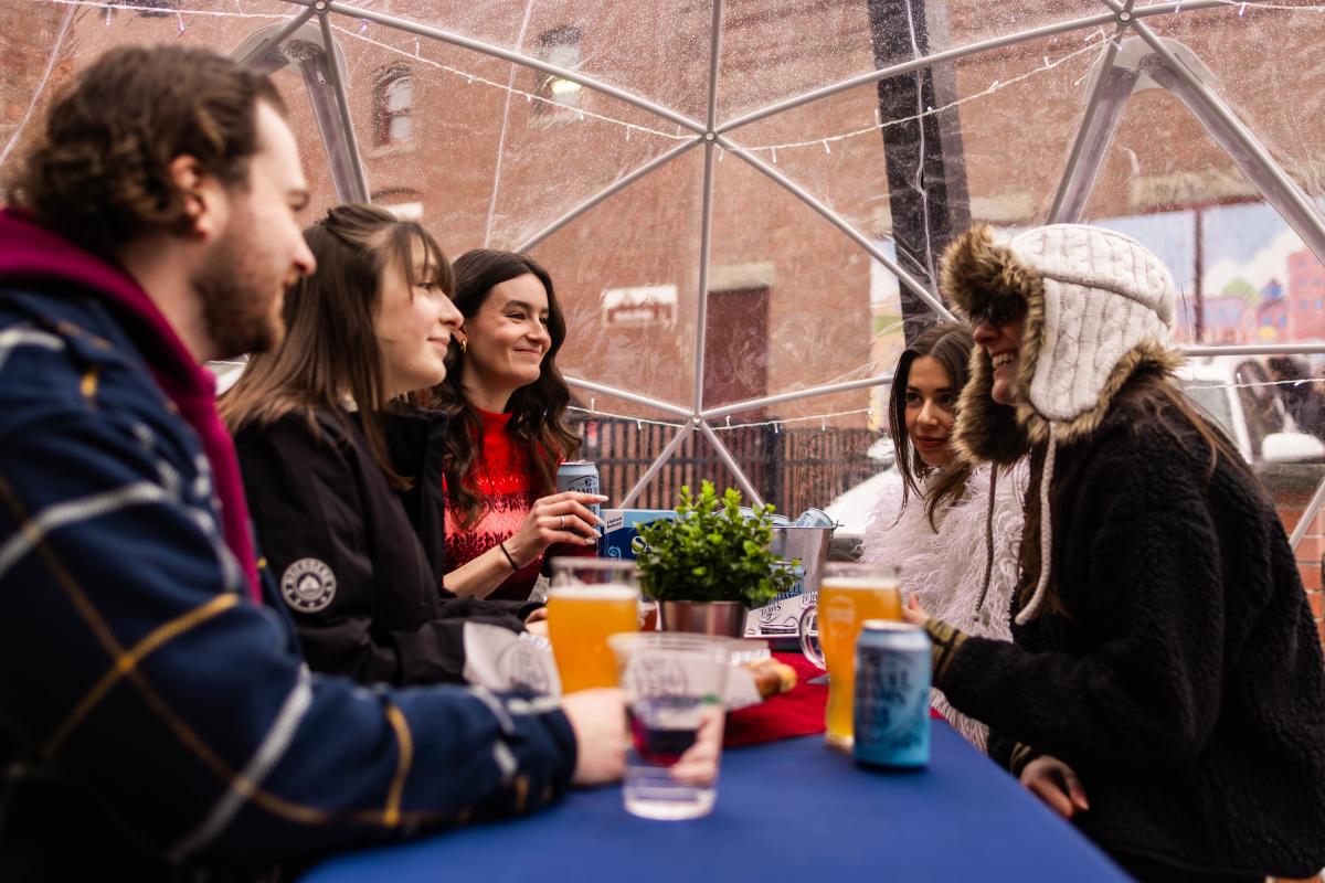 people drinking and smiling in a winter igloo