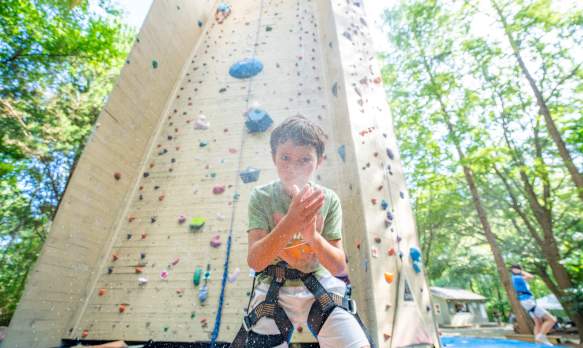 Boy getting ready to climb rock wall.