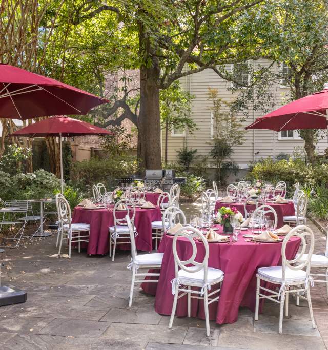 Chairs and Tables with pink tablecloths in an outdoor garden setting