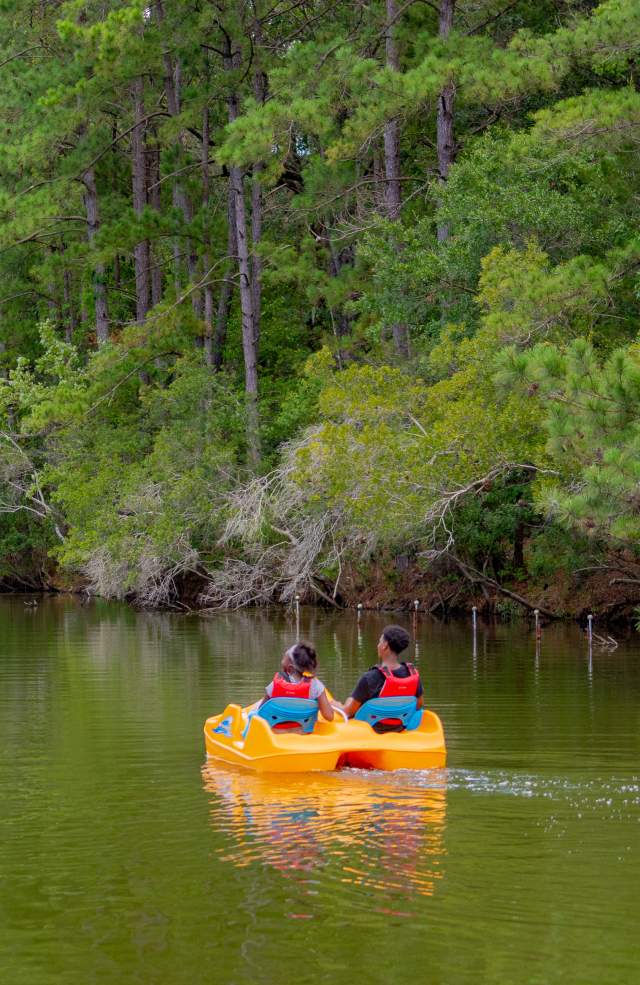 Two people in pedal boats on the lake