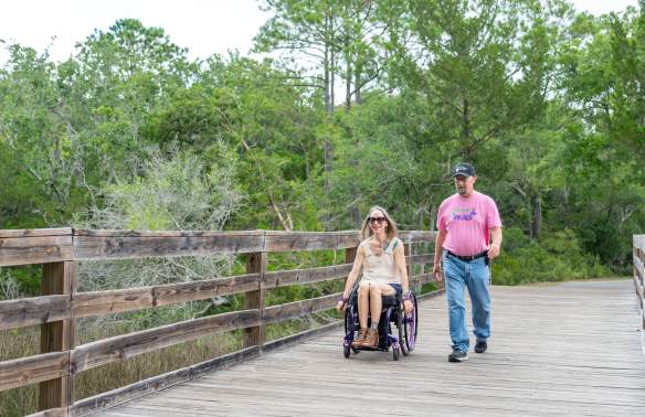 two people on a park boardwalk