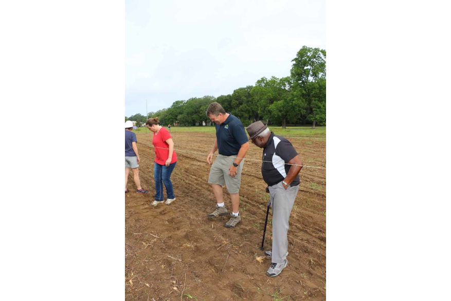Tamping down soil after seeds have been planted.