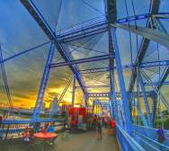 Tables and food vendors set up on the Purple People Bridge at sunset.
