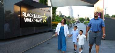 A family walks through the entrance of the Cincinnati Black Music Walk of Fame