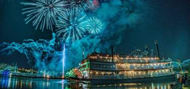 The image is of the BB Riverboat at night with fireworks in the background.