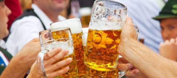 Four hands holding large glass steins of beer at Newport Oktoberfest