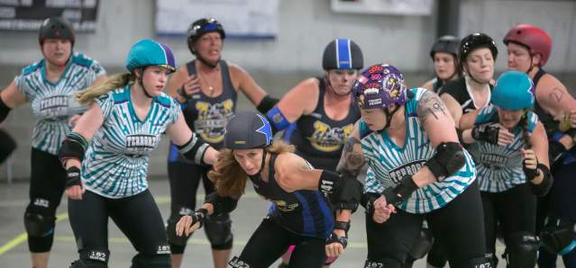 A group of skaters move along the track.