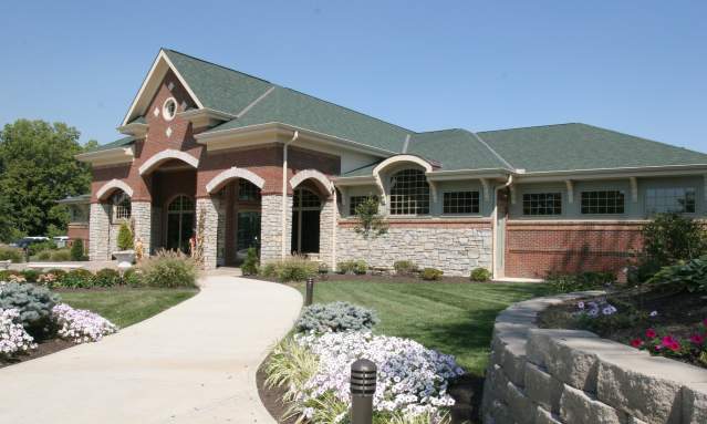 A path lined with plants leads to the entrance of the Drees Pavillion.