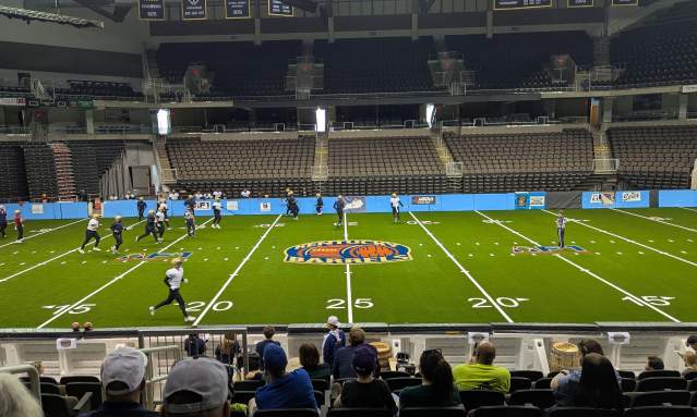 An arena football team practices at an indoor space.