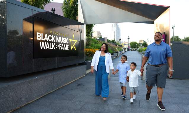 A family walks through the entrance of the Cincinnati Black Music Walk of Fame