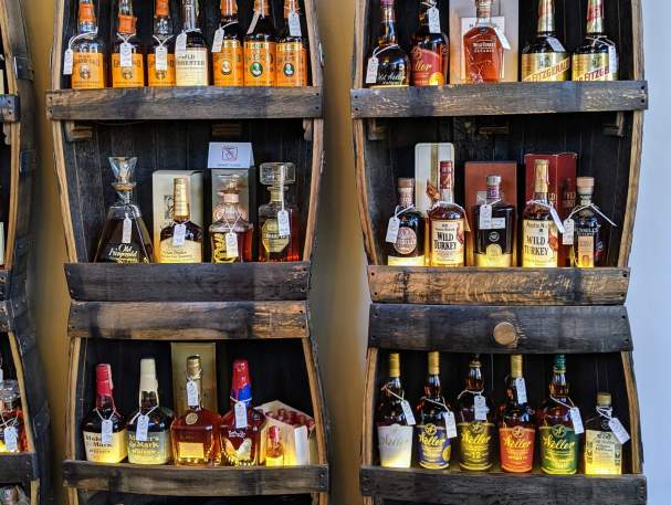 Two tall shelves holding dozens of bottles of vintage bourbon at Revival Vintage Spirits