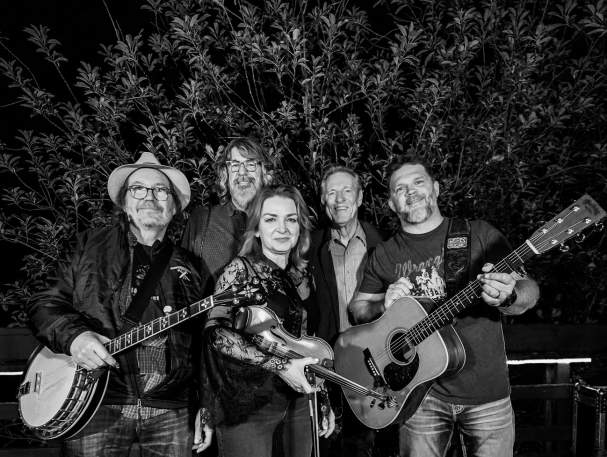 A group of people facing the camera holding instruments.