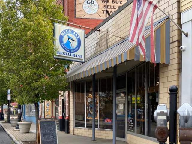 The image is of the outdoor facade of the Blue Jay Restuarant with their sign on display above the door.