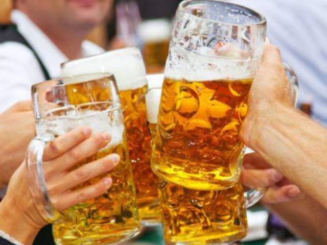 Four hands holding large glass steins of beer at Newport Oktoberfest