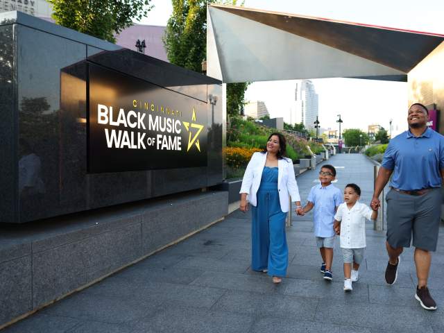 A family walks through the entrance of the Cincinnati Black Music Walk of Fame
