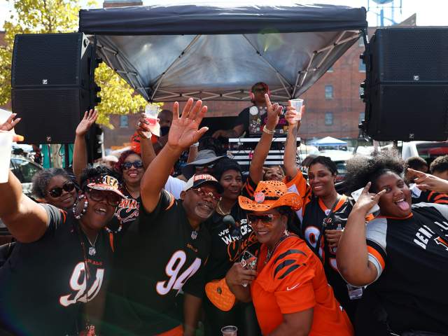 A group of Bengals fans tailgate outside of Longworth Hall before a game.