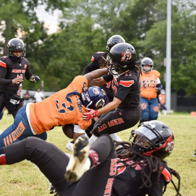 A player performs a leaping tackle