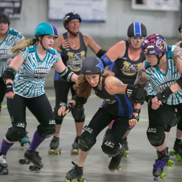 A group of skaters move along the track.