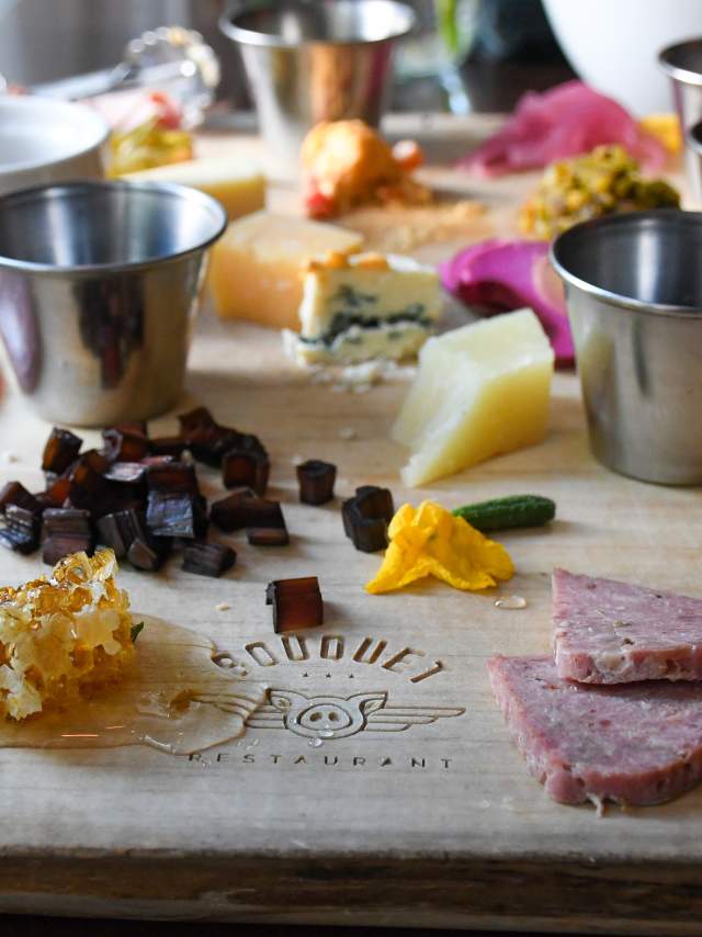 A charcuterie board of cheeses, meats, pickles and dried fruits