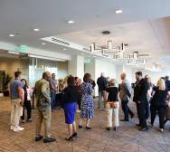A group of event attendees mingle in a hotel event space.
