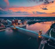 Sunset in the background over the Ohio river with the John A. Roebling Suspension bridge spanning from NKY to Cincy