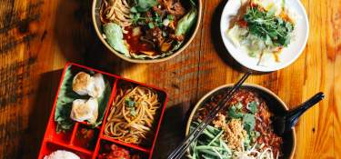 An array of dishes sit on a wooden table.