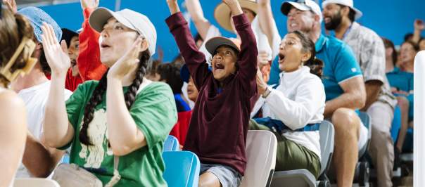 Rows of seated fans at the Cincinnati Open cheer during a tennis match