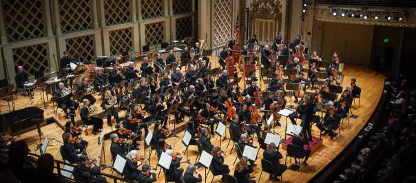 A group of musicians are assembled onstage at the Cincinnati Symphony Orchestra.