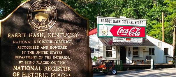 A brown sign noting that Rabbit Hash Kentucky is on the National Historic Register in front of the famous Rabbit Hash General Store
