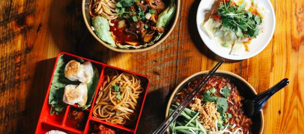 An array of dishes sit on a wooden table.