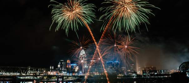 Gold and green fireworks burst in the sky high above the Cincinnati skyline